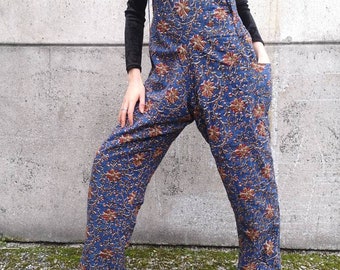 May include: Blue floral print overalls with brown straps. The overalls have a relaxed fit and are made of a soft, comfortable fabric.