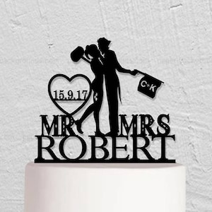 May include: Black silhouette cake topper of a couple kissing with a heart that says "15.9.17" and a sign that says "C-K". The topper says "Mr & Mrs Robert" below the couple.