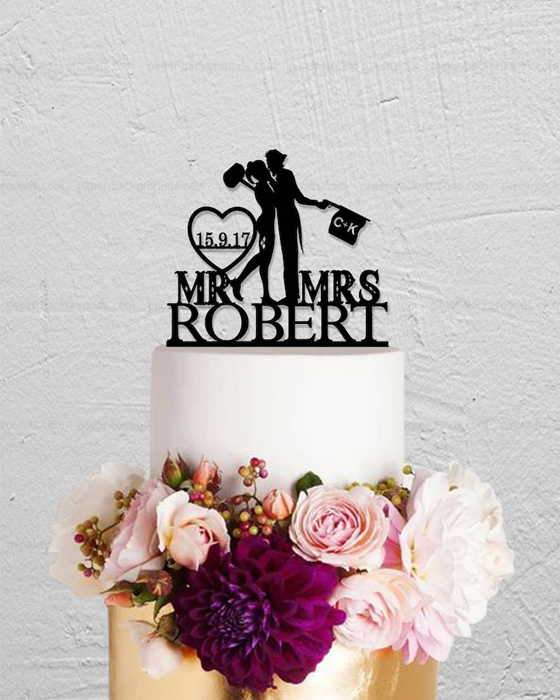 May include: Black silhouette cake topper of a couple kissing with a heart that says "15.9.17" and a sign that says "C-K". The topper says "Mr & Mrs Robert" below the couple.