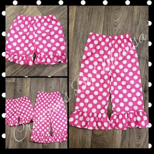May include: Pink and white polka dot shorts with a ruffled hem. The shorts are made of a soft, comfortable fabric and are perfect for a variety of occasions.