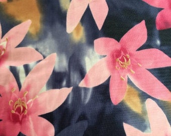 May include: Pink and white floral print fabric with a blue background. The fabric is measured with a ruler in inches.