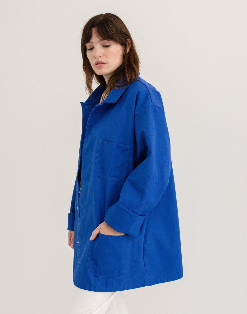 May include: A long-sleeved, royal blue work jacket with a button-up front and two large pockets.
