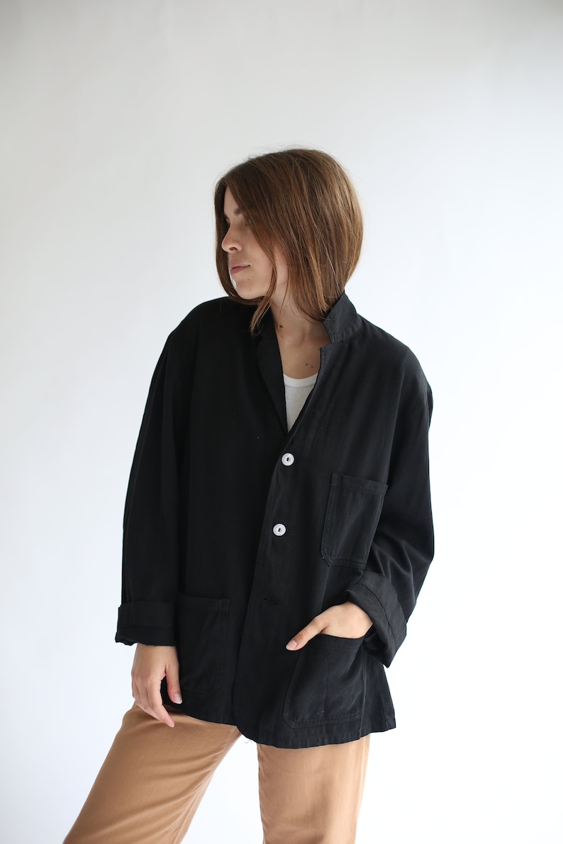 May include: A black utility jacket with a button closure and two large pockets. The jacket has a relaxed fit and is made of a soft, lightweight fabric.