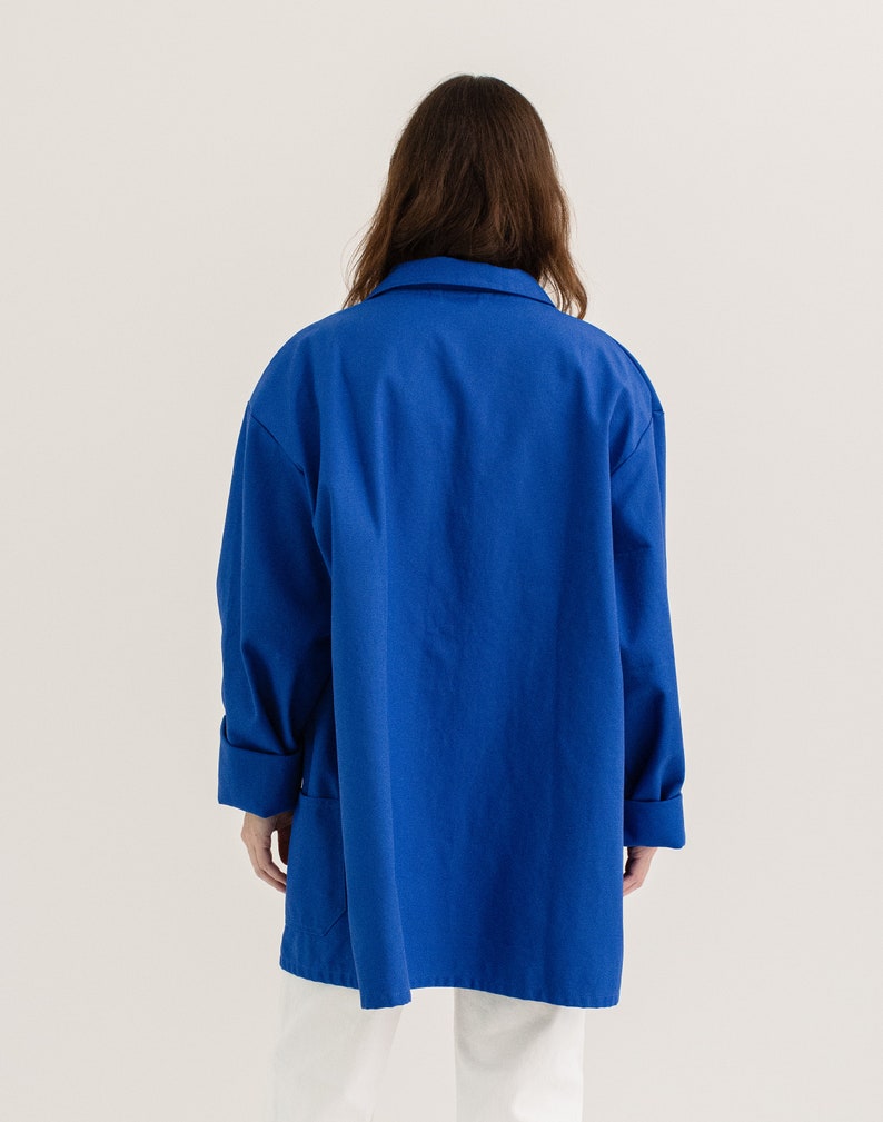 May include: A long-sleeved, royal blue work shirt with a relaxed fit and a button-up collar.