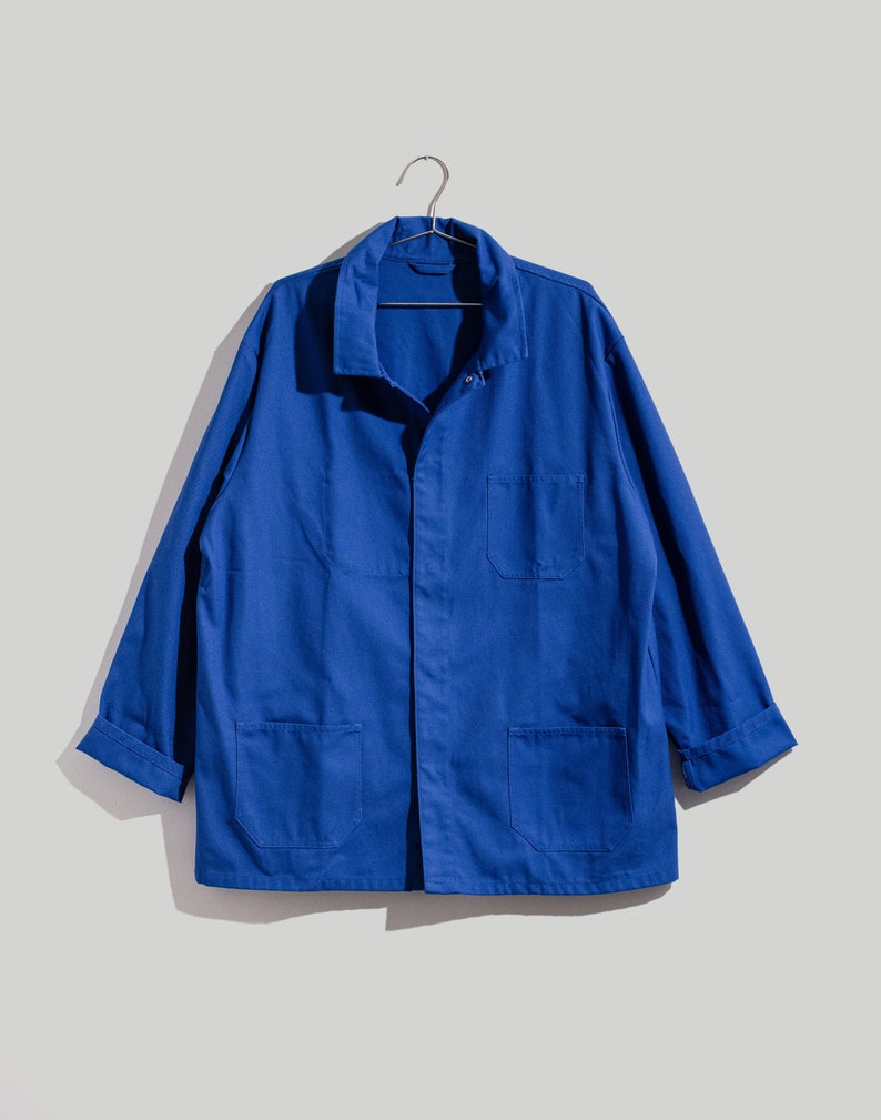 May include: A blue work jacket with long sleeves, a button-up front, and multiple pockets.