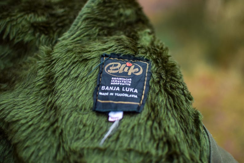 May include: A green fuzzy jacket with a black label that reads "Blijuch Industria Konfekcjie Banja Luka Made in Yugoslavia".