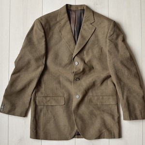 May include: A brown blazer with a three-button closure and two front pockets.