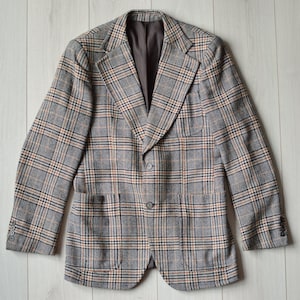May include: A brown, black, and beige plaid blazer with two pockets and a button closure.