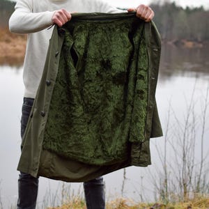 May include: A green, lined jacket with a fluffy lining. The jacket is open and the lining is visible.