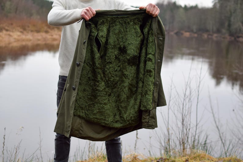 May include: A green, lined jacket with a fluffy lining. The jacket is open and the lining is visible.