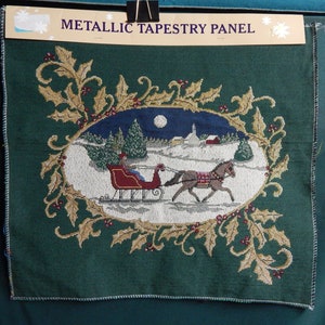 May include: A green tapestry panel with a gold and brown floral border. The center of the panel features a winter scene with a horse-drawn sleigh, a snowy landscape, and a full moon. The text "METALLIC TAPESTRY PANEL" is printed at the top of the panel.