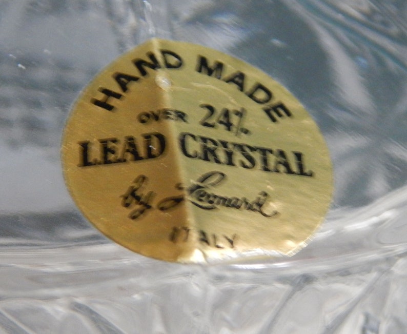 May include: A gold sticker with black text that reads "Hand Made Over 24% Lead Crystal by L. Leonard ITALY".
