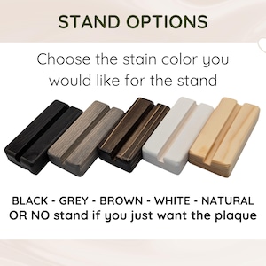 May include: Five rectangular wooden stands with a centre groove, displayed in a row. The colours from left to right are black, grey, dark brown, white, and natural wood. Text reads: STAND OPTIONS, Choose the stain colour you would like for the stand, BLACK - GREY - BROWN - WHITE - NATURAL OR NO stand if you just want the plaque.