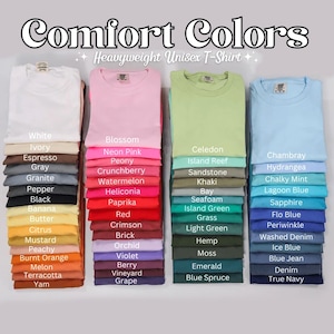 May include: Folded Comfort Colors heavyweight unisex t-shirts in a range of colours, including pink, green, and blue. Each stack is labelled with the colour name, such as "Blossom," "Khaki," and "Sapphire."