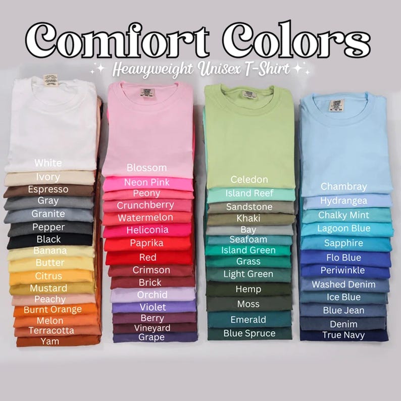 May include: Folded Comfort Colors heavyweight unisex t-shirts in a range of colours, including pink, green, and blue. Each stack is labelled with the colour name, such as "Blossom," "Khaki," and "Sapphire."