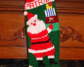 May include: A red and green knitted Christmas stocking with the name "Patrick" embroidered on the front. The stocking features a Santa Claus figure with a white beard and a red suit.