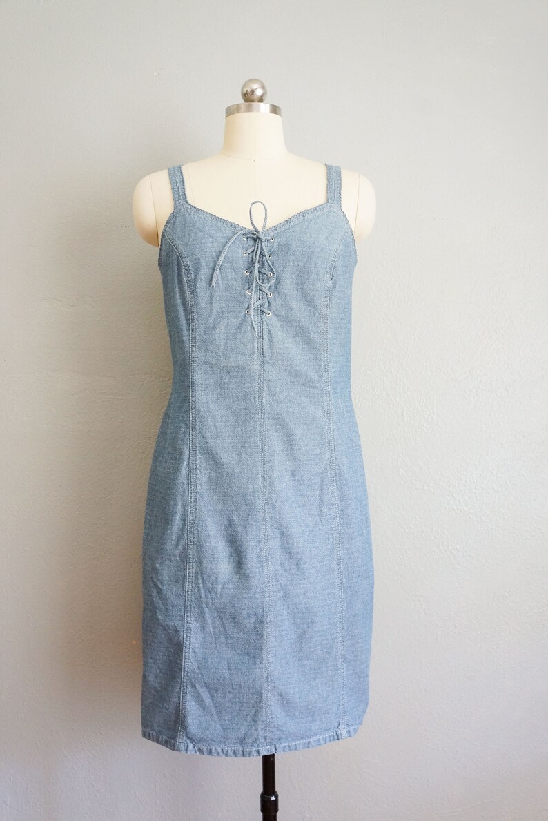 May include: A light blue denim dress with a lace-up detail at the bodice.