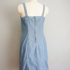 May include: A light blue denim dress with thin straps and a zipper down the back.