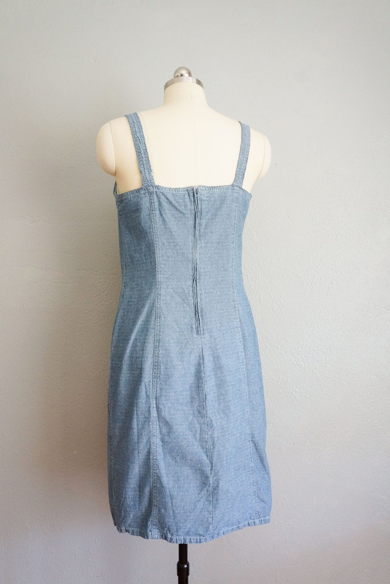 May include: A light blue denim dress with thin straps and a zipper down the back.