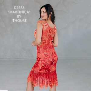 May include: A red crochet dress with a floral pattern. The dress has a fitted bodice and a flowing skirt. The dress is labeled "Dress "Martini&ccedil;a" by JThouse".