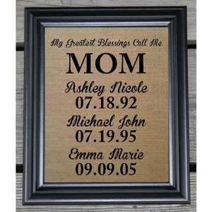 May include: A framed burlap print with the text "My Greatest Blessings Call Me MOM" and the names of three children with their birth dates.