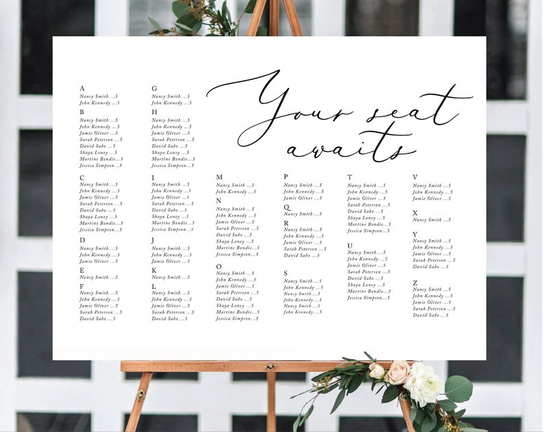 May include: A white wedding seating chart with the text "Your seat awaits" in cursive script. The chart is divided into alphabetical sections with guest names listed under each letter.