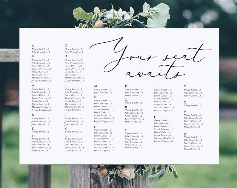 May include: A white seating chart with black text lists names and table assignments for a wedding reception. The text "Your seat awaits" is written in cursive at the top of the chart.