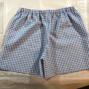 May include: Blue and white gingham shorts with an elastic waistband.
