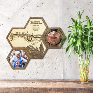 Op de afbeelding: Houten display in zeshoekig ontwerp met een marathonmedaille en een foto. Het display bevat een kaart van Londen, de tekst "Marathon Run Day of London" en lopersdetails. De medaille is koperkleurig.
