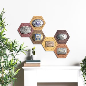 May include: A wall-mounted display consisting of six interlocking wooden hexagons in varying brown tones. Each hexagon features a recessed centre holding a metallic race medal. The medals include text such as Beast of Burden, Spartan Race, Black Canyon, and World's End 100km.
