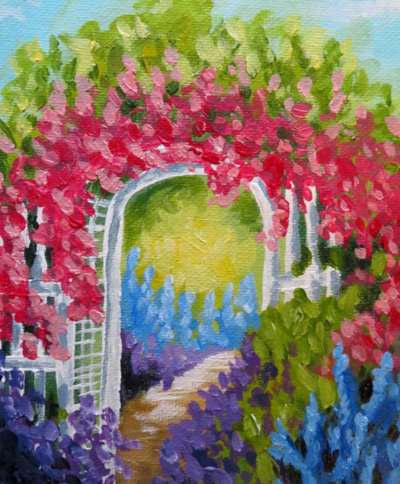 May include: A white garden archway covered in pink flowers with a path leading through it. The path is lined with purple and blue flowers.