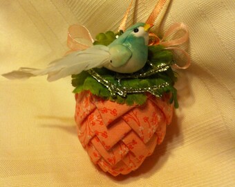 Light coral floral print fabric pinecone ornament with green bird.