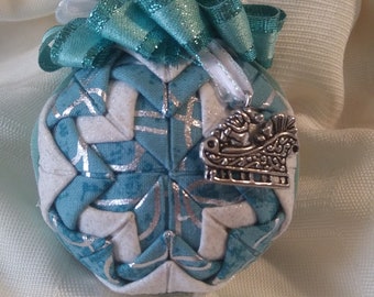 Teal print and white sparkle fabrics folded star Christmas ball ornament was handcrafted with a Santa sleigh charm.