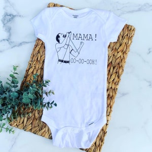 May include: White baby onesie with a black and white illustration of Freddie Mercury singing with the words "MAMA! OO-OO-OOOH!" printed on it.