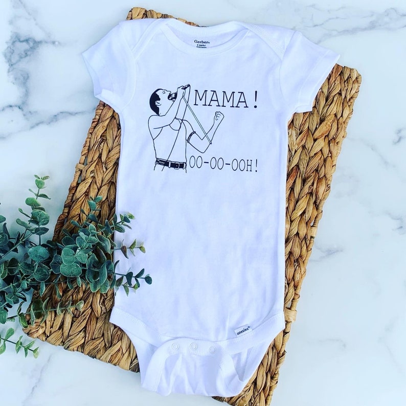 May include: White baby onesie with a black and white illustration of Freddie Mercury singing with the words "MAMA! OO-OO-OOOH!" printed on it.