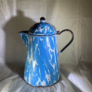 May include: A blue and white marbled enamel coffee pot with a black lid and handle.