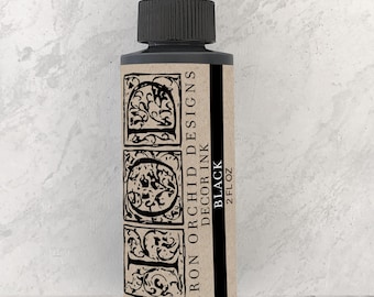 Peut inclure: Une bouteille de 2 fl oz d'encre décorative noire Iron Orchid Designs. La bouteille a un bouchon noir et une étiquette avec le nom de la marque et les détails du produit.