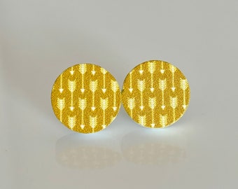 May include: A pair of gold-colored earrings with a white arrow pattern.