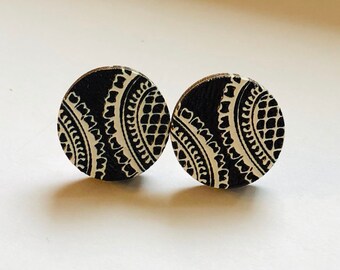 May include: A pair of black and white round wooden earrings with a paisley pattern.