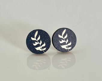 Könnte beinhalten: Ein Paar schwarze Ohrstecker mit einem weißen Blattdesign.