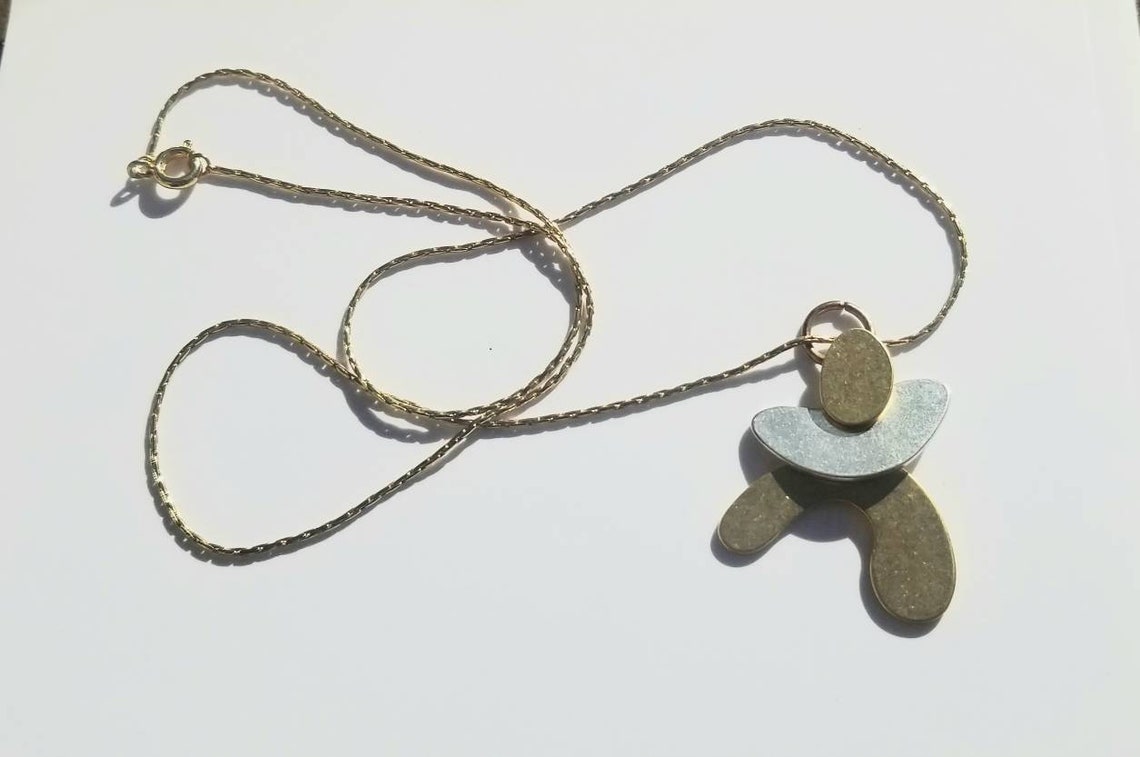 Cute brass and metal small person pendent from Madewell on