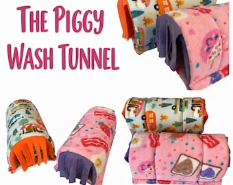 May include: The Piggy Wash Tunnel text appears next to fleece tunnels for small pets. One tunnel features a light blue background with camping motifs, and the other is pink with breakfast food prints. Both have fringed ends in orange or purple.