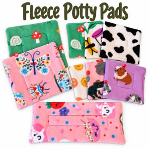 May include: A collection of square and rectangular fleece potty pads featuring various colorful prints including butterflies, mushrooms, cow spots, frogs, and small animals, with the text Fleece Potty Pads displayed at the top.