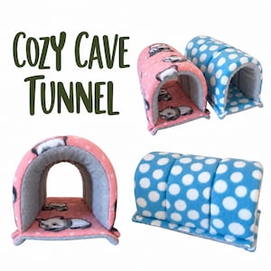 May include: Cozy Cave Tunnel text appears next to two soft fleece pet tunnels. One tunnel is pink with a panda print and gray interior, while the other is blue with white polka dots and a gray interior, featuring a curved arch design.