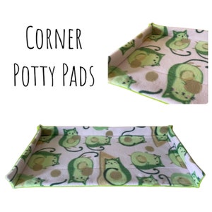 May include: Corner potty pads featuring a white background adorned with a repeating pattern of green avocado cats. The pads are edged with lime green trim. The text "CORNER POTTY PADS" is in black script.
