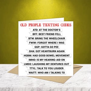 May include: A humorous greeting card featuring the text "OLD PEOPLE TEXTING CODES" in red. The card displays a list of texting abbreviations with amusing definitions, including "BTW: BRING THE WHEELCHAIR" and "LMDO: LAUGHING MY DENTURES OUT". The card is on a brown envelope.