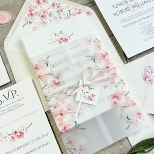 pink cherry blossom printed on vellum paper wrapped around a wedding invitation