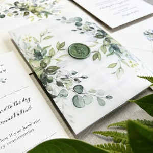 A botanical wedding invitation printed on quality 350gsm ivory cardstock The invite is wrapped in a greenery printed 150gsm vellum jacket. Finished & sealed with a luxury wax seal.