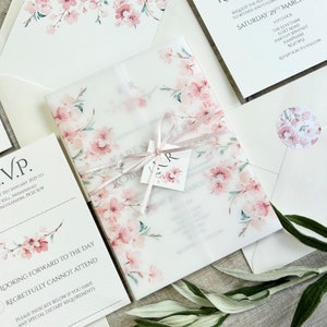 Cherry blossom printed on a vellum paper wrapped around a wedding invitation. Tied together with satin ribbon and finished with a personalised tag.