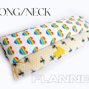 May include: A long neck flannel heating pad with a rainbow heart pattern on one side and a yellow honeycomb pattern with black bees on the other side.  The text "LONG/NECK" is at the top of the image and "FLANNEL" is at the bottom.